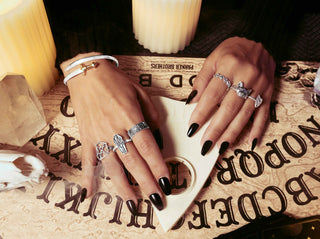 Woman wearing silver rings playing with ouija board