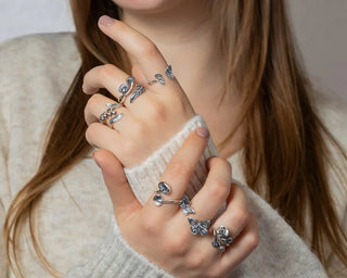 Hand wearing many silver rings