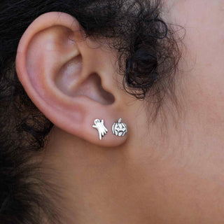 Close-up of an ear wearing two small silver earrings.