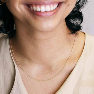 Close-up of a person wearing a Curb Chain - 14K Gold Filled with a neutral background