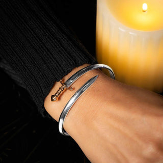 Mixed Metal Sword Bracelet on model wrist next to candle