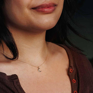 14 karat gold crescent moon necklace with dainty 14k gold chain on neck