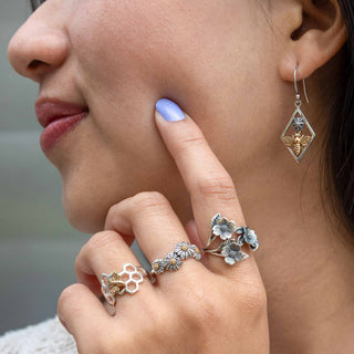 Woman wearing three silver rings and dangle earrings