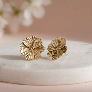 Bronze Flower Earrings on pink background