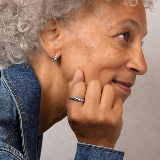 Women wearing matching earring and ring - twisted silver motif