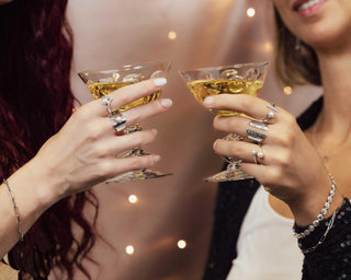 Women with drinking glasses toasting wearing silver jewelry 