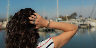 Woman standing in marina wearing knot jewelry