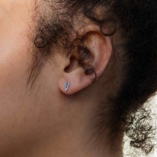 Close-up of an ear with a small angel wing stud earring