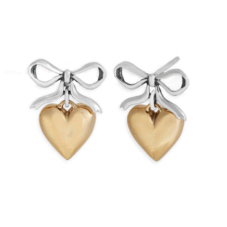 Pair of earrings with gold heart pendants and silver bows on a white background
