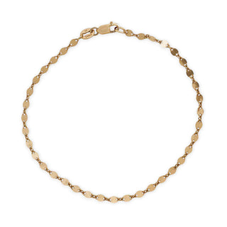 A delicate yellow gold chain bracelet with flat, oval disc links, displayed in a circular shape against a plain white background.