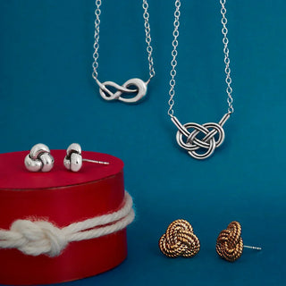 Silver and gold knot-themed jewelry set on a blue background