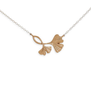 Gold ginkgo leaf necklace on a white background