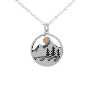 Silver necklace with a mountain and tree pendant on a white background