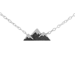Mountain-shaped pendant on a chain against a white background