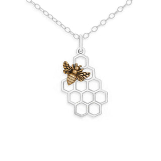 A silver honeycomb pendant necklace featuring a small bronze bee charm, shown on a clean white background.