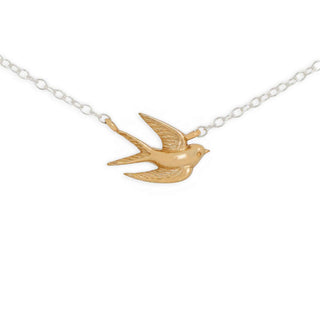 A gold swallow pendant necklace on a delicate silver link chain, shown against a plain white background.
