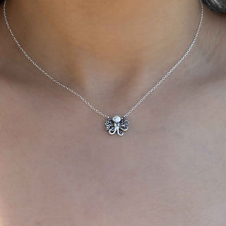Silver necklace with a small pendant on a person's neck