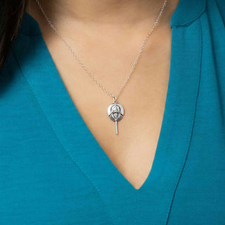 Silver necklace with a pendant on a person wearing a teal top