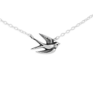 A silver-toned necklace featuring a detailed flying bird pendant with textured engravings, shown on a clean white background.