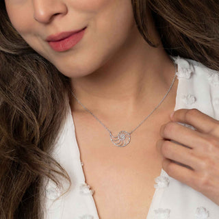 Woman wearing a silver necklace with a shell pendant