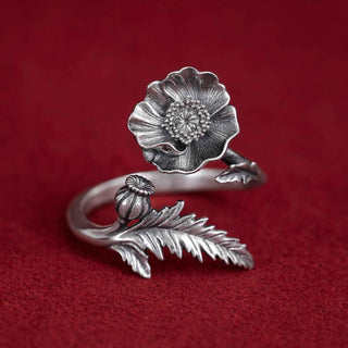 Silver floral ring on a red background