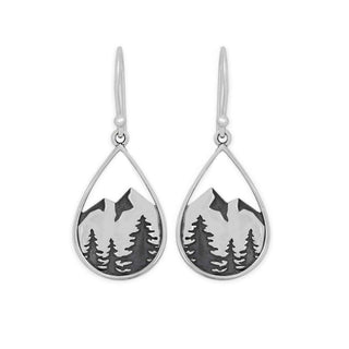 A pair of silver teardrop dangle earrings featuring an engraved mountain and pine tree landscape design, shown against a plain white background.