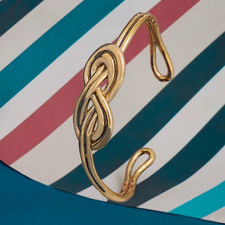 Gold bracelet on a striped background