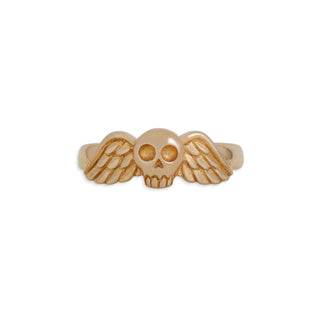 Gold ring with skull and wings design on a white background