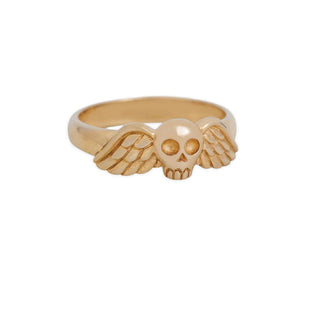 Gold ring with skull and wing design on a white background