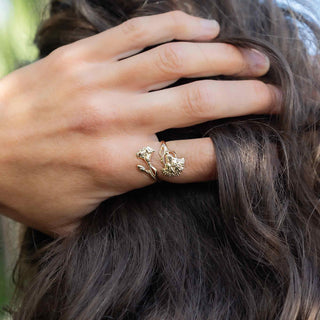 Close-up of a hand with bronze carnation ring on a blurred natural background