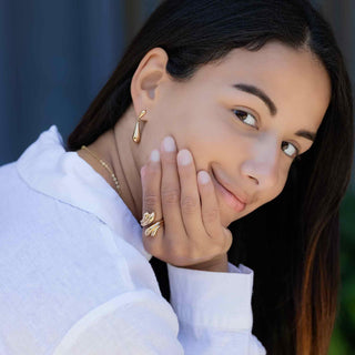 Woman wearing Bronze earrings and Bronze Double Teardrop Ring, with a blurred background