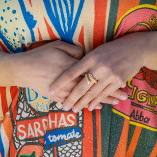 Hand wearing sardine ring on colorful dress