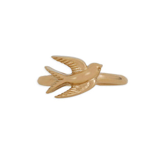 A small gold-tone bird-shaped hair claw clip with wings spread, shown on a plain white background.