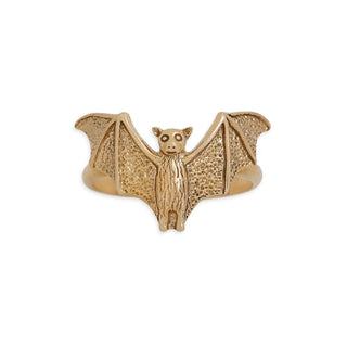A gold bat-shaped ring with textured wings and a detailed head, shown on a plain white background.
