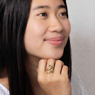 Woman wearing a bronze phoenix ring with a white background