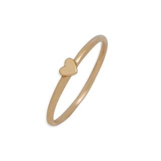 A minimalist gold ring featuring a small, polished heart charm set on a thin band, shown against a plain white background.