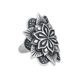 A silver-toned ring featuring a large, intricate floral mandala design with oxidized black recesses, shown on a plain white background.