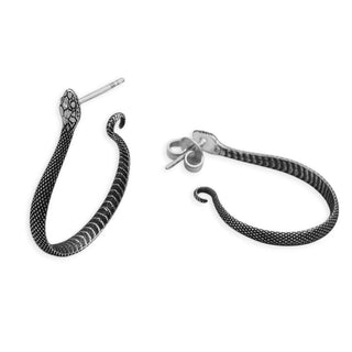 Silver snake earrings on white background