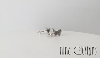 Turntable video of silver butterfly post earrings