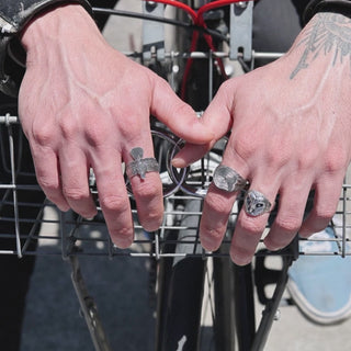 Close-up video of tree stump ring, eagle ring and barn owl ring on hands of male model