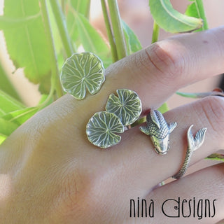 Close-up video of tree stump ring, eagle ring and barn owl ring on hands of male model
